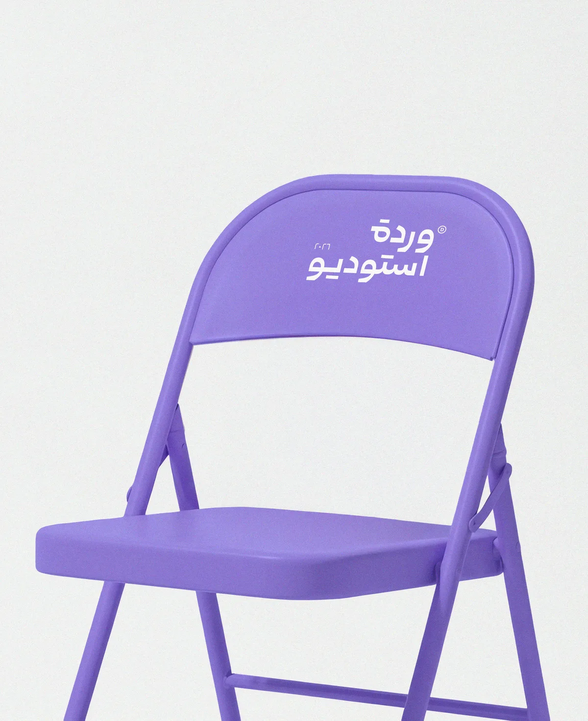 كرسي بنفسجي يحمل شعار وردة استوديو — من هوية الاستوديو 2026